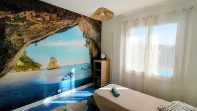 a bedroom with a wall mural of a sea cave at Serinity Villa - Piscine - proche Castres in Viviers-lès-Montagnes
