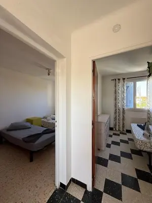 a bedroom with a bed and a checkerboard floor at escapade les pied dans l'eau in Port-la-Nouvelle