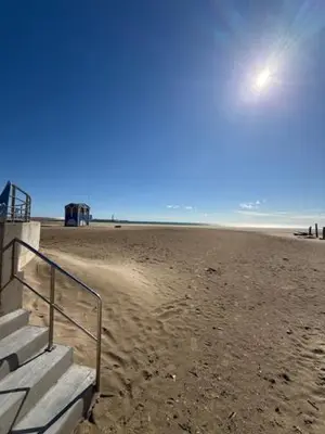 a sandy beach with stairs on the beach at escapade les pied dans l'eau in Port-la-Nouvelle
