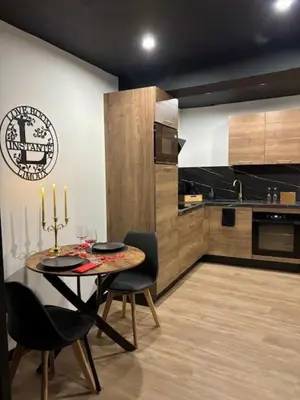 a dining room with a table and chairs and a kitchen at Love Room L'instanté - 