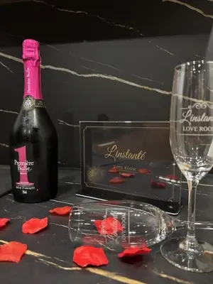 a bottle of wine and two glasses on a table at Love Room L'instanté - 