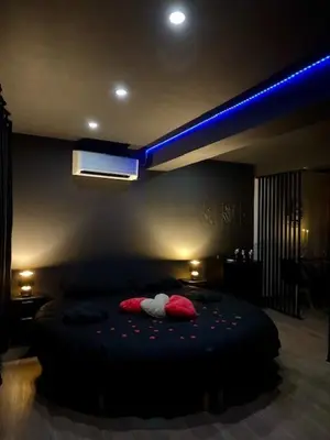 a room with two red pillows and a neon sign at Love Room L'instanté - 
