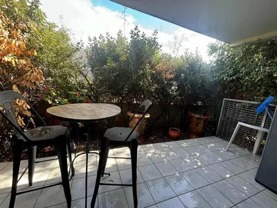 a patio with a table and two chairs on a patio at Confortable appartement rez de jardin- terrasse - parking in Narbonne