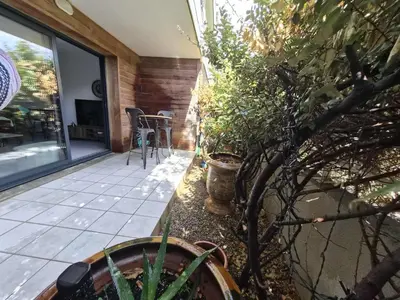 a patio with a table and some plants on it at Confortable appartement rez de jardin- terrasse - parking in Narbonne