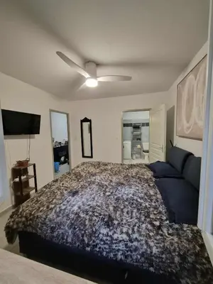 a bedroom with a bed and a ceiling fan at Confortable appartement rez de jardin- terrasse - parking in Narbonne