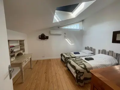 a bedroom with two beds and a desk and a skylight at Gîte de l'atelier in Sorèze in Sorèze
