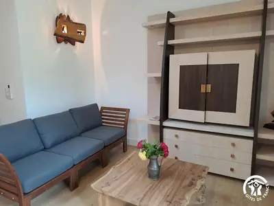 a living room with a blue couch and a table at Gîte de l'atelier in Sorèze in Sorèze