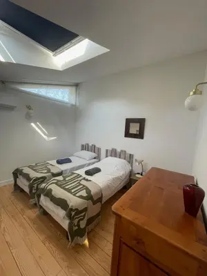a bedroom with two beds and a wooden table at Gîte de l'atelier in Sorèze in Sorèze