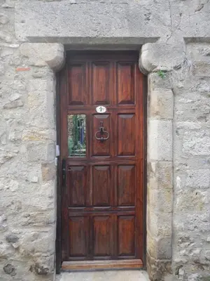 a large wooden door in a stone wall at Lagrasse Romantic house, enclosed garden, pool in Lagrasse