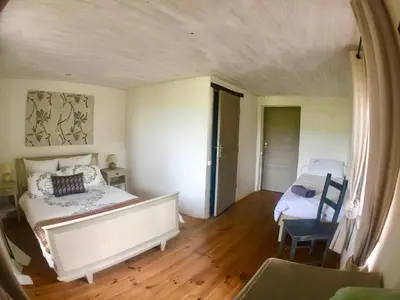 a bedroom with a bed and a chair in it at Maison Tranquil in Bellegarde-du-Razès