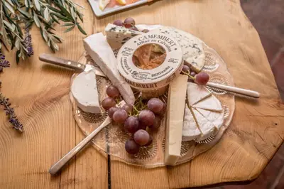 a wooden table with a plate of food and grapes at Maison Tranquil in Bellegarde-du-Razès