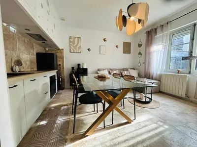 a bedroom with a bed and a chair and a chandelier at Les Dames Carcas in Carcassonne