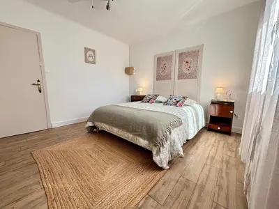a bedroom with a bed and a wooden floor at Magnifique T3, OU Suite Elégance , à 4 min en voiture des Grands buffets in Narbonne