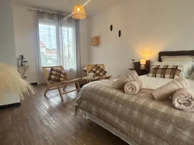 a bedroom with two beds and a table and a chair at Magnifique T3, OU Suite Elégance , à 4 min en voiture des Grands buffets in Narbonne