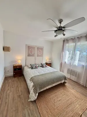 a bedroom with a bed and a ceiling fan at Magnifique T3, OU Suite Elégance , à 4 min en voiture des Grands buffets in Narbonne