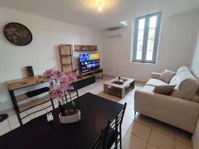 a living room with a couch and a table at Vue sur la cité médiévale -Clim-Parking in Carcassonne