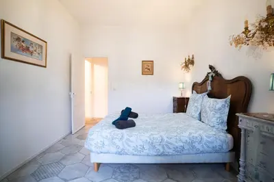 a teddy bear sitting on a bed in a bedroom at CAR-Volterra Cottage-AN in Carcassonne