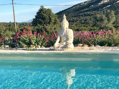 a large white statue sitting next to a pool of water at Villa Kéona , gîte 5 étoiles avec piscine privée et vue nature in Vingrau