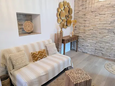 a living room with a couch and a brick wall at Le Petit Capoine 3 - T2 en plein centre de Carcassonne in Carcassonne