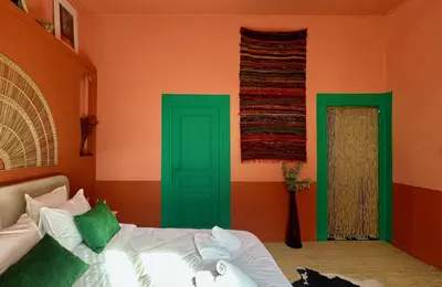 a bedroom with green and orange walls and a bed at La Casa De Frida charme & poésie in Narbonne