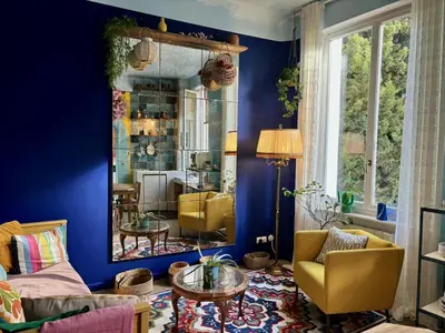 a living room with blue walls and a mirror at La Casa De Frida charme & poésie in Narbonne