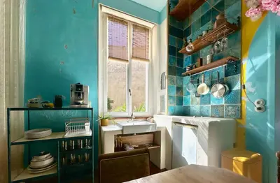a blue kitchen with a sink and a window at La Casa De Frida charme & poésie in Narbonne