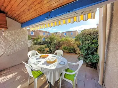 a white table and chairs on a patio with a table and chairs at Holiday Home Bora Bora 2-3 by Interhome in Gruissan