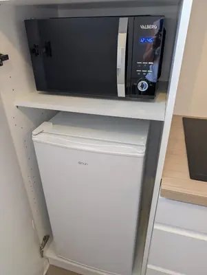 a microwave sitting on top of a refrigerator at Le Petit Capoine 2- T2 Plein Centre de Carcassonne- in Carcassonne