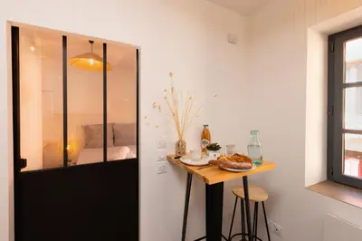 a room with a small table and a window at Le Petit Capoine 2- T2 Plein Centre de Carcassonne- in Carcassonne