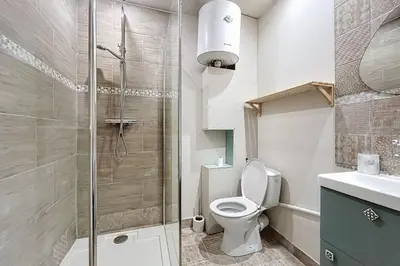 a bathroom with a toilet and a glass shower at Charming studio in the city center of Narbonne in Narbonne