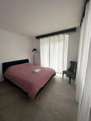 a bedroom with a red bed and a chair at House with garden near Castres city center in Castres