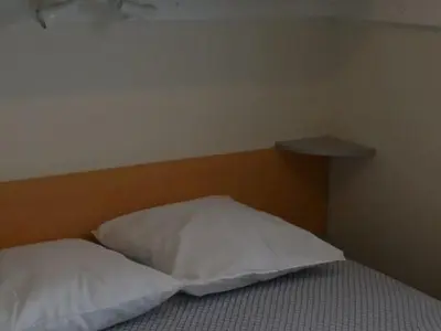 a bed with two white pillows in a room at Mobil-home confortable avec terrasse à Sournia - API-1-52-358 in Sournia