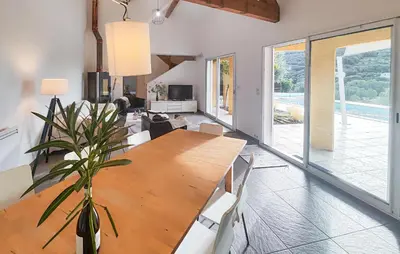 a large dining room with a wooden table and chairs at Awesome Home In Roquebrun in Roquebrun