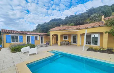 a house with a swimming pool in front of a house at Awesome Home In Roquebrun in Roquebrun