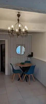 a dining room with a table and chairs and a chandelier at Maison de village in Sigean