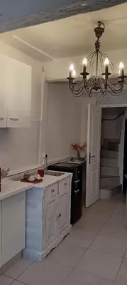 a kitchen with a chandelier in the middle of it at Maison de village in Sigean