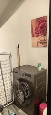 a washing machine in a room with a painting on the wall at Maison de village in Sigean