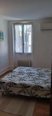 a bedroom with a bed in a room with a window at Maison de village in Sigean