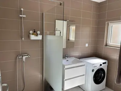 a bathroom with a washing machine and a washer at Gutenberg's Nest in Carcassonne