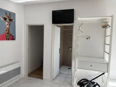 a room with a tv on a wall with a closet at Gutenberg's Nest in Carcassonne