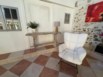 a living room with a chair and a table at La Villa Narbo Martius in Ornaisons
