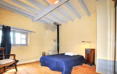 a bedroom with a blue bed and a window at Apaisante Maison Authentique in Sainte-Foi