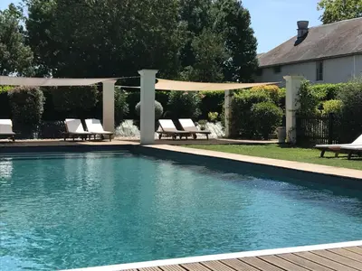 a swimming pool with chairs and a pergola at Le Pavillon - Demeure de prestige avec14 chambres pour 30 pers - Piscine in Garrevaques