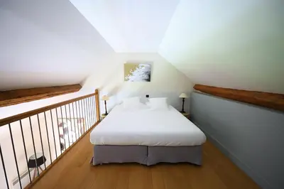 a bedroom with a white bed in a attic at Le Pavillon - Demeure de prestige avec14 chambres pour 30 pers - Piscine in Garrevaques