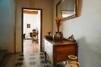 a room with a vase on a dresser and a mirror at Le séminaire in Fitou