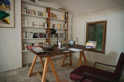 a wooden table in a room with a book shelf at Le séminaire in Fitou