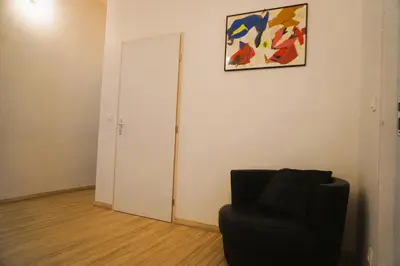 a room with a chair and a painting on the wall at Le séminaire in Fitou