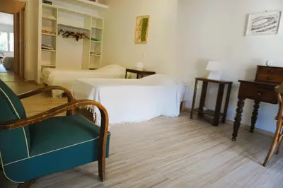 a bedroom with two beds and a chair and a table at Le séminaire in Fitou