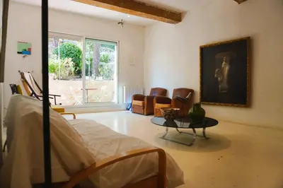 a room with a bed and a table and chairs at Le séminaire in Fitou