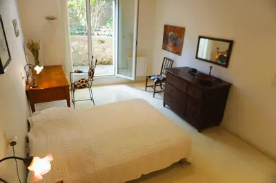 a bedroom with a bed and a dresser and a window at Le séminaire in Fitou